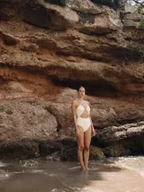 Malla enteriza blanca con diseño cut out en la parte delantera, escote halter con fruncido y tiras multiposición.