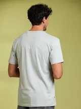 Remera de manga corta color arena, con cuello redondo y un bolsillo de parche en el pecho.