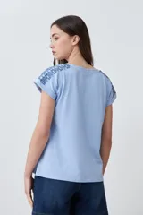 Remera de algodón color celeste melange, con cuello en V y mangas cortas con dobladillo.