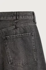 Jeans de corte barrel fit confeccionados en denim de algodón rígido, con diseño de cinco bolsillos y efecto lavado. Presentan un corte amplio en cadera y muslos con forma curva que se estrecha hacia el tobillo, tiro medio y largo cropped.