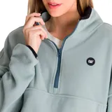 Buzo polar celeste de corte holgado, con cuello alto con cierre de media cremallera azul y logo de la marca bordado en el pecho.