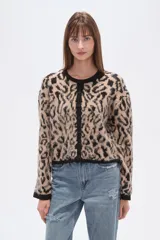 Cardigan de tejido de punto, corto, con estampado animal print en tonos beige y negro. Presenta cuello redondo y ribetes negros en el borde frontal, puños y ruedo.