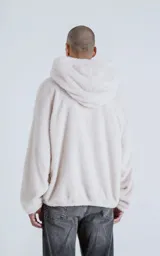 Hoodie oversize de piel sintética tipo corderito, color off-white, con capucha ajustable y bolsillo canguro frontal.