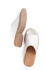 Sandalias chatas de cuero color crudo, fabricadas en Uruguay.