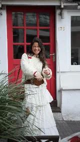 Buzo tejido a mano en lana merino, color crema con diseño de corazones rojos distribuidos en la prenda. Presenta cuello redondo, puños y ruedo con detalles en color rojo.