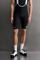 Short de ciclismo con tirantes, color blanco, de tejido elástico y diseño ergonómico con badana y detalles gráficos en negro.