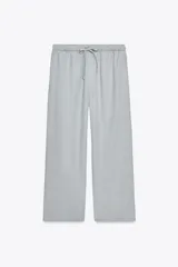 Pantalón jogger de la colección Zara Woman, color gris claro, confeccionado en hilatura con algodón y lyocell. Presenta tiro medio, cintura elástica ajustable con cordones, bolsillos laterales ocultos en costura y pierna ancha.