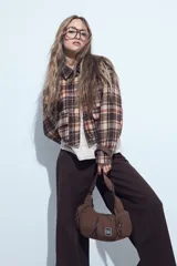 Campera de paño con diseño de cuadros en tonos negro, gris y beige. Presenta cuello camisero, cierre frontal con botones y corte corto.