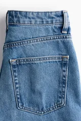 Jean barrel de tiro alto en denim de algodón rígido, con diseño curvo en las piernas y corte de cinco bolsillos.