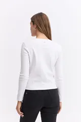 Remera de manga larga color marrón, con cuello redondo y estampa sutil en el pecho con diseño de juego de ta-te-ti y texto.