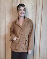 Sobreacamisa de paño color camel con cuello camisero, cierre frontal de botones y dos bolsillos delanteros con solapa.
