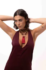 Collar corto con cadena de piedras naturales en tonos tierra y un dije central metálico en forma de herradura del que cuelgan tres borlas de seda en color bordó.