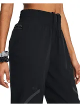 Pantalón deportivo Under Armour de corte al tobillo, color negro, con cintura elástica de talle alto y cordón interno. Presenta bolsillos laterales y detalles reflectantes en los laterales de las piernas.