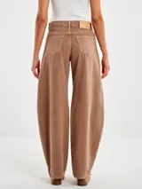 Pantalón de jean color marrón con diseño de silueta amplia y redondeada tipo balloon, de tiro medio y corte holgado.