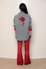 Camisa de jean liviano en tono celeste claro, con corte oversize, cuello clásico, cierre frontal con botones metálicos, bolsillo en el pecho y detalle de bordado en el puño.