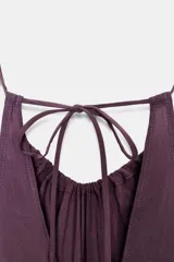 Vestido midi color lila de cuello halter y tirantes finos ajustables en la espalda.