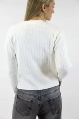 Sweater azul marino de punto con diseño de trenzas o espigas en relieve, cuello redondo y mangas largas con puños y dobladillo acanalados.