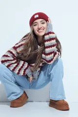 Cardigan de tejido de punto con diseño de rayas horizontales en tonos azul, gris y crema. Presenta escote en V, cierre frontal con botones grandes y mangas largas con puños anchos acanalados.