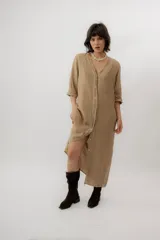 Vestido largo de lino color tostado, de manga larga, con escote redondo y diseño amplio y fresco. Cuenta con un delicado bordado en la espalda con motivos marinos y la frase "no se lo digas".