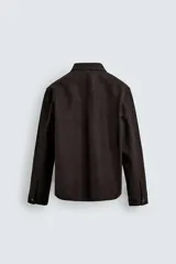 Sobrecamisa de corte relajado confeccionada en tejido efecto piel color marrón oscuro. Presenta cuello solapa, cierre frontal con botones metálicos, mangas largas con puños abotonados y dos bolsillos de plastrón con solapa en el pecho.