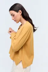 Sweater de tejido de punto color beige, con escote en V y calce holgado.