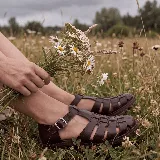 Sandalias franciscanas de cuero marrón oscuro, con diseño de tiras entrelazadas, tira en T con hebilla metálica ajustable y suela con plataforma.