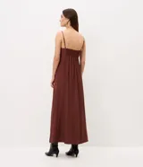 Vestido midi evasê marrón con breteles finos, escote corazón y corte en la cintura. Presenta silueta fluida con caída amplia y bolsillos laterales.