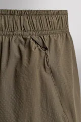 Short de running confeccionado en tejido técnico ligero y elástico con estructura. Cuenta con forro interior, cintura elástica ajustable con cordón, bolsillo trasero con cierre oculto, bolsillos laterales multifunción y aberturas laterales en las perneras.