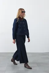 Jean de corte amplio y tiro medio, con diseño de costuras verticales frontales y bolsillos laterales tipo parche. Presenta un acabado en tono azul clásico.