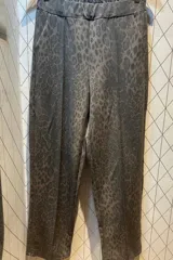 Pantalón de corte recto con estampado animal print en tonos beige y gris. Presenta cintura elástica y diseño holgado.