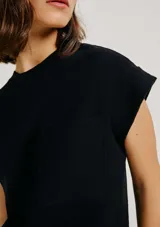 Vestido corto negro de manga corta, con corte recto, escote redondo y un bolsillo aplicado en el pecho.