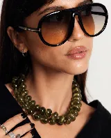 Collar de cuentas redondas y aplanadas con efecto marmolado en tonos grisáceos, con cierre metálico dorado.