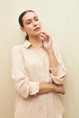 Camisa color café con textura sutil, cuello clásico, botones forrados a tono y mangas largas con puños fruncidos.