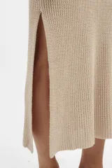 Vestido largo tejido en jersey color beige, con escote redondo y corte con abertura en los laterales.