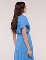 Vestido midi color azul, de silueta fluida estilo bohemio, con escote en V, pechera con detalle de encaje, mangas cortas con vuelo, cintura elástica con lazo ajustable y falda escalonada con volados.