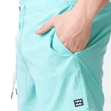 Short de baño Billabong de color turquesa, con cintura elástica y cordón ajustable blanco. Presenta bolsillos laterales y una pequeña etiqueta con el logo de la marca en el borde inferior izquierdo.