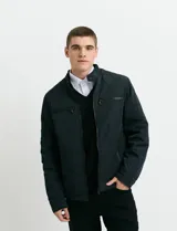 Campera de estilo casual con cierre frontal, cuello alto con broche y bolsillos laterales con cierre. Presenta un diseño liso y funcional, ideal para uso diario.