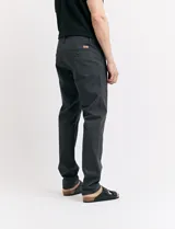 Pantalón de vestir marrón, de corte recto, con bolsillos laterales y traseros. Se ajusta a la cintura con cinturón de cuero marrón.