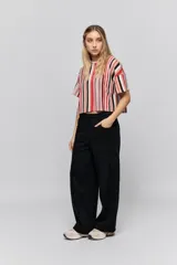 Babucha de calce relajado color negro, con cintura elastizada, cordón de ajuste y bolsillos laterales. Presenta un diseño de pernera amplia y cómoda.
