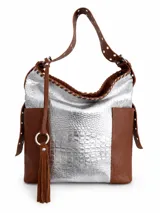 Cartera de cuero combinada en color plateado con textura de cocodrilo y cuero tostado en los laterales y la manija, con detalles de tachas y flecos colgantes.