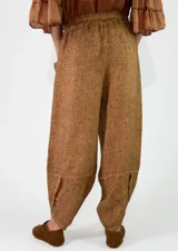 Pantalón de lino color amarillo mostaza, de corte bombacho y relajado, con bolsillos delanteros aplicados y cintura elástica.