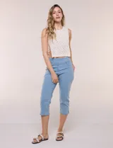Pantalón capri en denim elastizado de calce entallado y estilo pull-on, color azul. Presenta cintura ancha totalmente elastizada, bragueta simulada, bolsillos delanteros redondeados con remaches metálicos, canesú anatómico y bolsillos traseros plaqué.