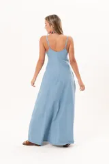 Vestido largo de denim fino y liviano, color celeste, con breteles finos, escote delicado, silueta entallada en la parte superior, falda amplia con recortes verticales y bolsillos laterales.