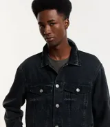 Campera de jean de hombre, color celeste claro con efecto desteñido y desgastado. Presenta cuello, manga larga, cierre frontal con botones blancos y dos bolsillos con solapa y botón en el pecho.