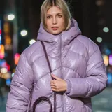 Campera puffer lila, acolchada y liviana, con capucha, cierre frontal, puños elásticos y dos bolsillos con cierre.