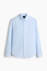 Camisa de vestir slim fit con diseño a rayas celestes y blancas, cuello inglés, cierre frontal de botones y mangas largas con puños abotonados.