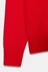 Jersey de manga larga confeccionado en hilatura de lana 100%, con escote en pico y acabado de punto fino.