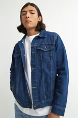 Campera de jean celeste con cuello clásico, cierre frontal con botones metálicos negros, bolsillos con solapa abotonada en el pecho y mangas largas con puños abotonados.