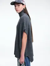Chaleco tipo poncho de tejido de punto color tostado, con cuello polera y diseño holgado con laterales abiertos.