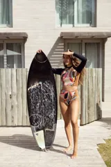 Conjunto de traje de baño compuesto por un top de mangas largas con estampado abstracto multicolor y una bombacha de tiro alto con laterales acanalados.